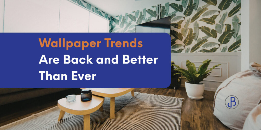 A modern living room with leafy wallpaper, a light wood coffee table, a plant, and large windows highlights the latest wallpaper trends, overlaid with the text "Wallpaper Trends Are Back and Better Than Ever. - Jeff Bryant Painting